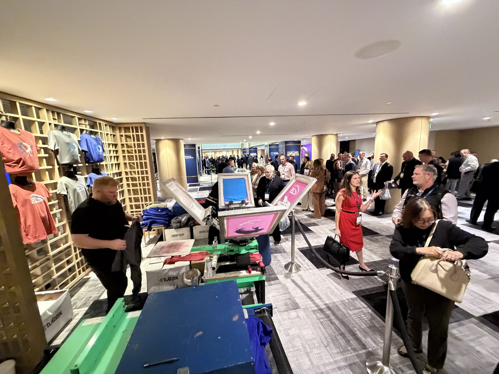 On-demand shirt printing and garment display wall in a hotel conference corridor